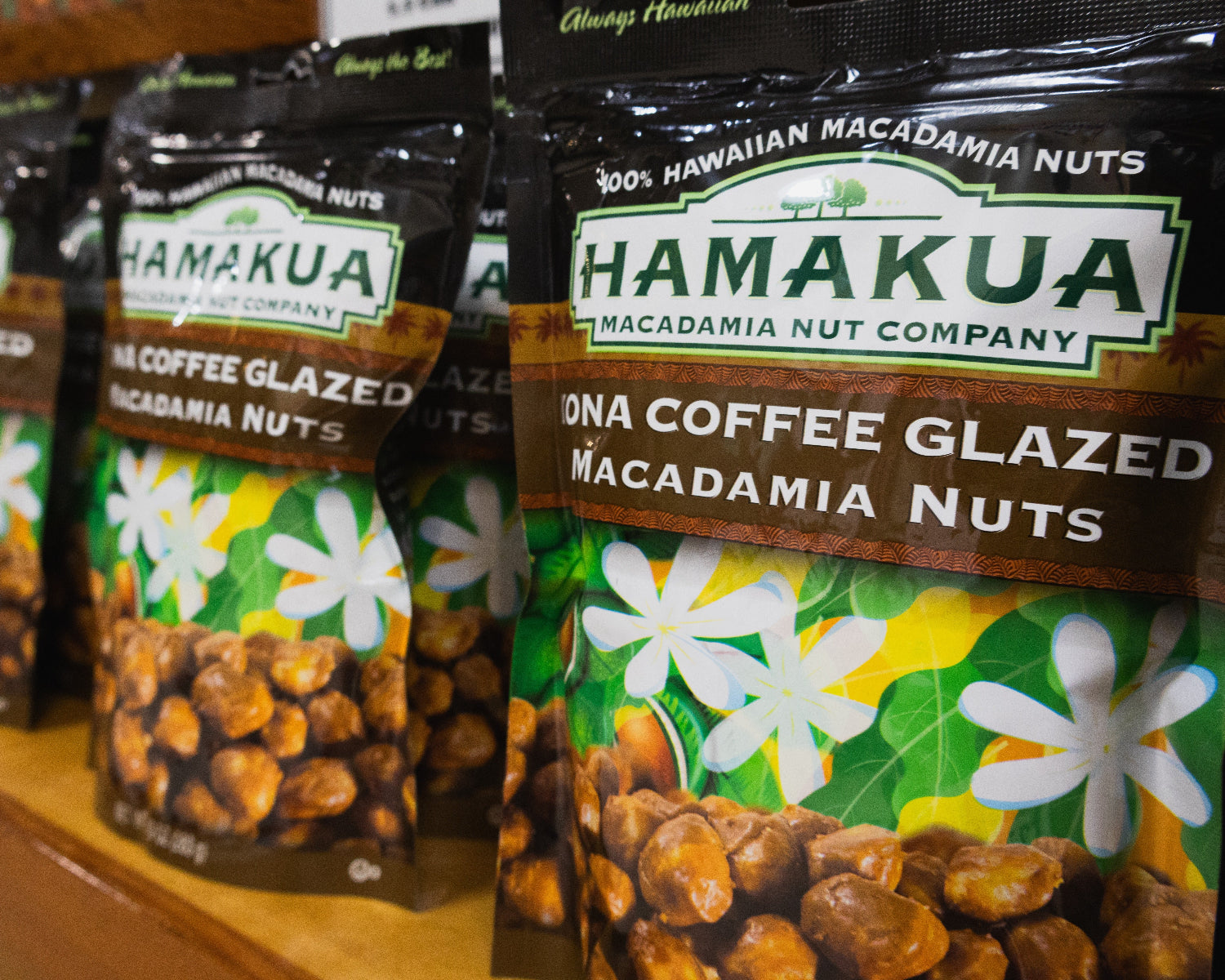Packages of Hāmākua Macadamia Nut Company Kona Coffee Glazed macadamia nuts on a shelf in the Visitor Center