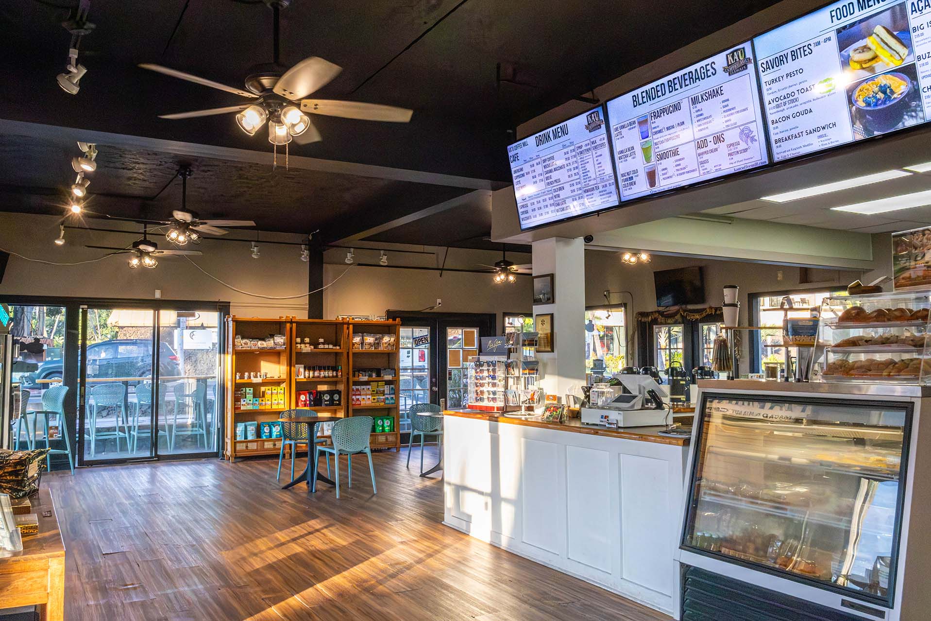 Interior of a coffee shop with seating area, counter, and display cases.