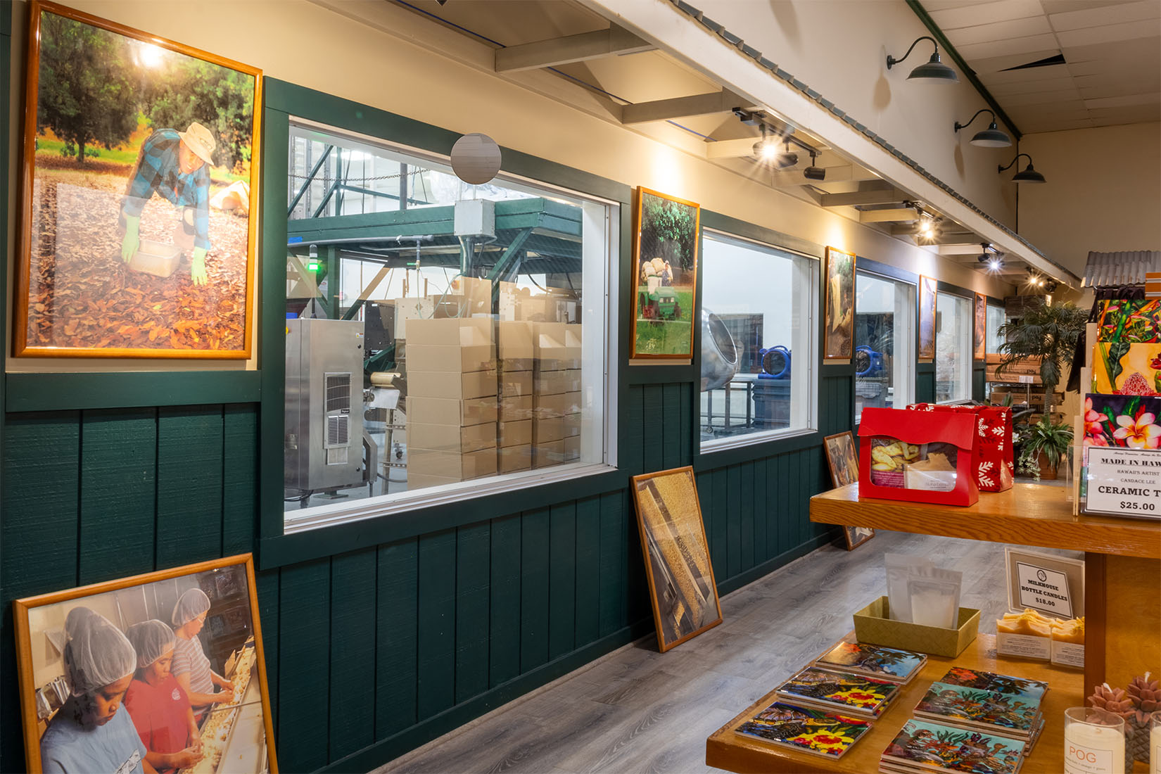Interior of the Visitor Center with green walls, framed pictures, and a window for viewing into the cannery