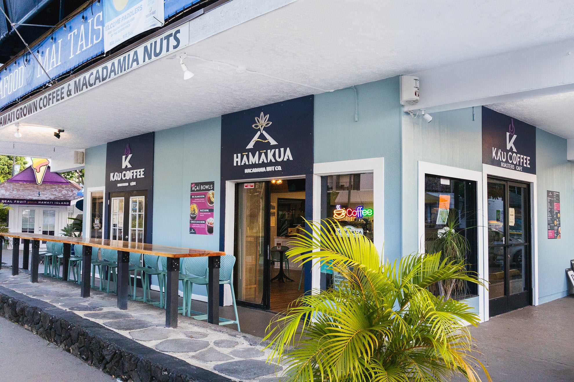 Front of Kaʻū Coffee Roasters Cafe with logos for the cafe and Hāmākua Macadamia Nut Company