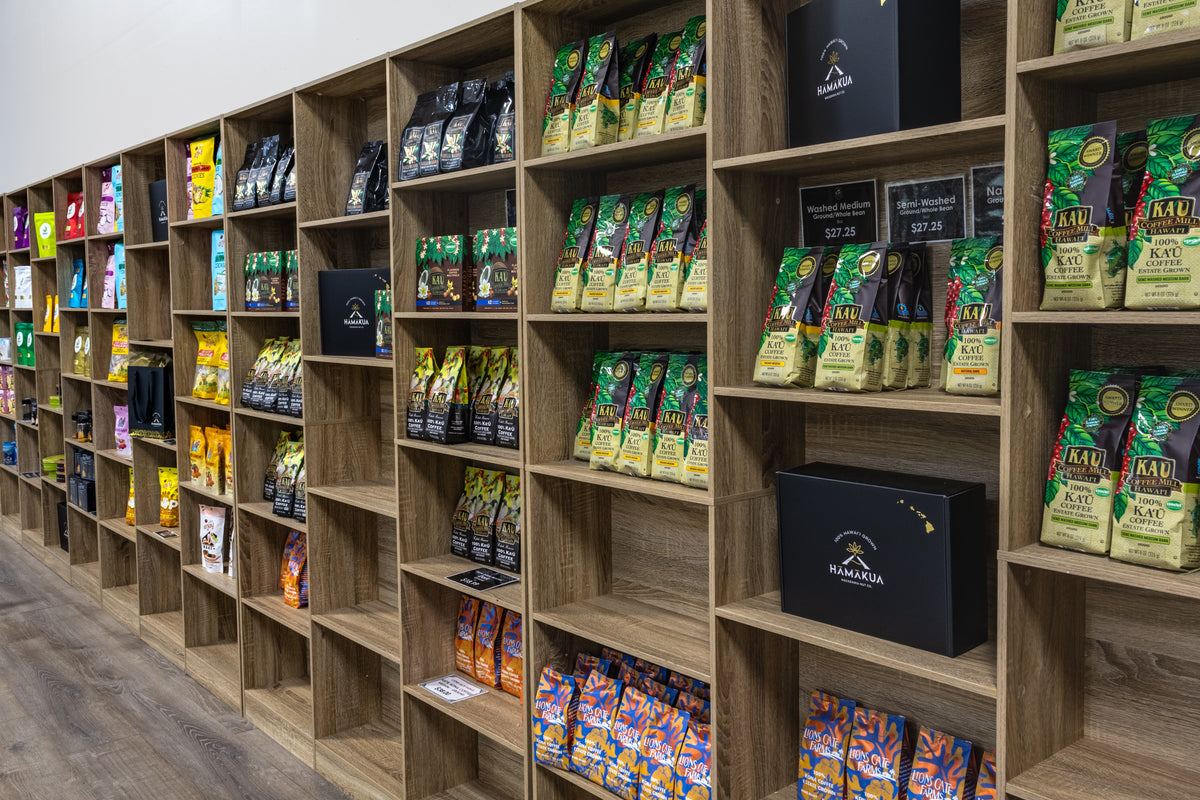 Wooden retail shelving units stocked with packaged coffee and other products.