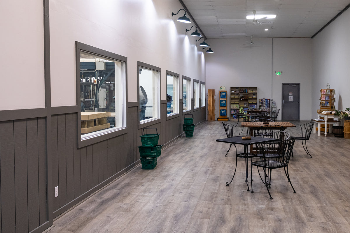 A long room with gray paneled walls and large windows looking into the cannery.