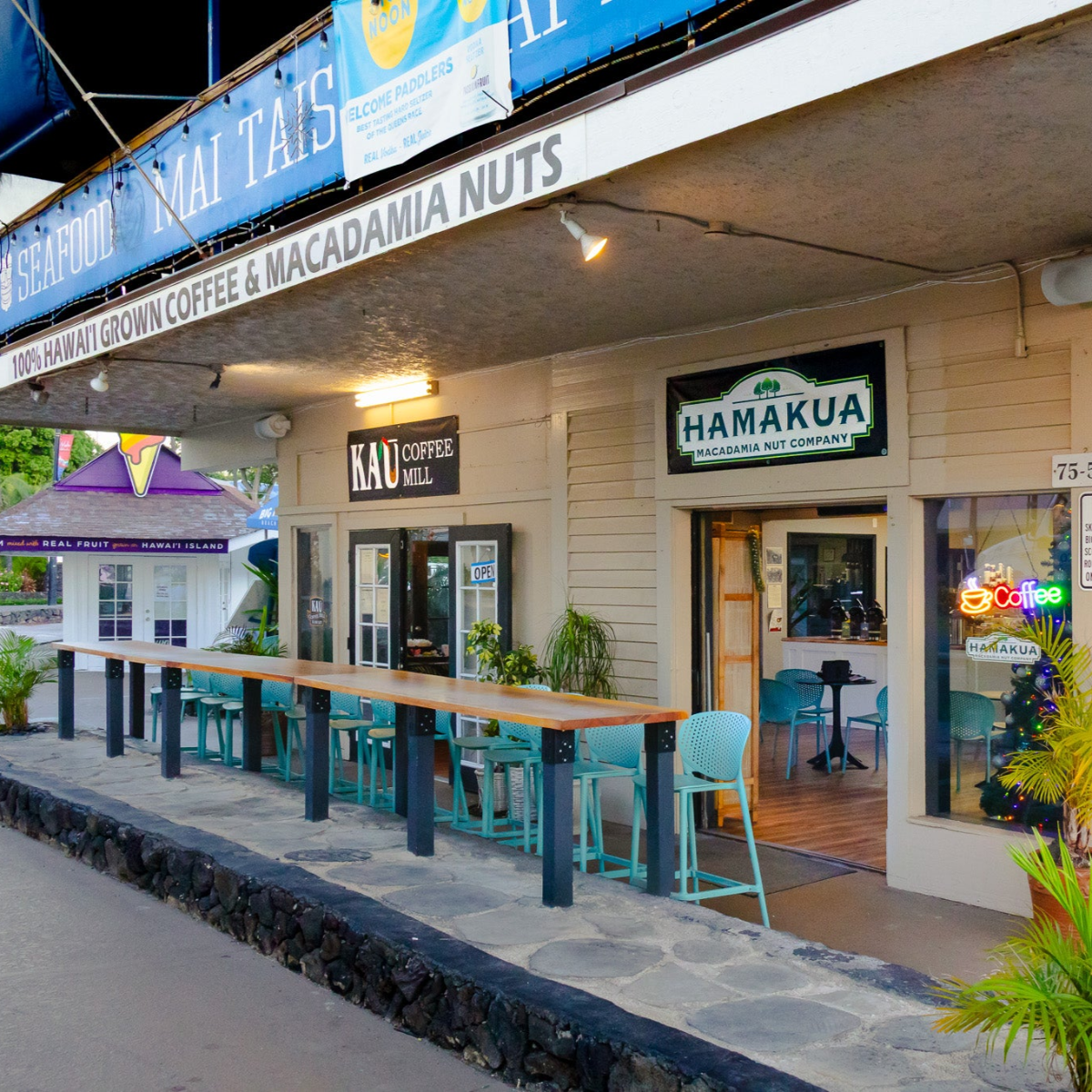Kaʻū Coffee Mill Cafe entrances and outdoor seating facing Kailua Bay and Aliʻi Drive