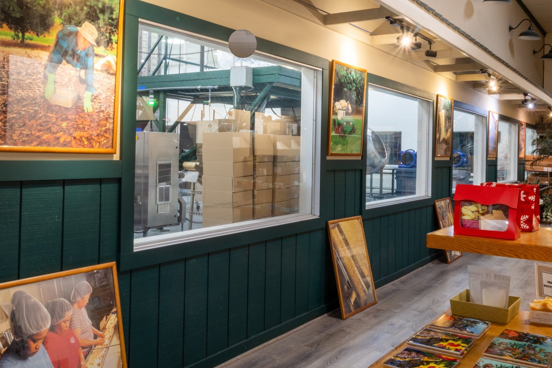 Interior of the Visitor Center with green walls, framed pictures, and a window for viewing into the cannery